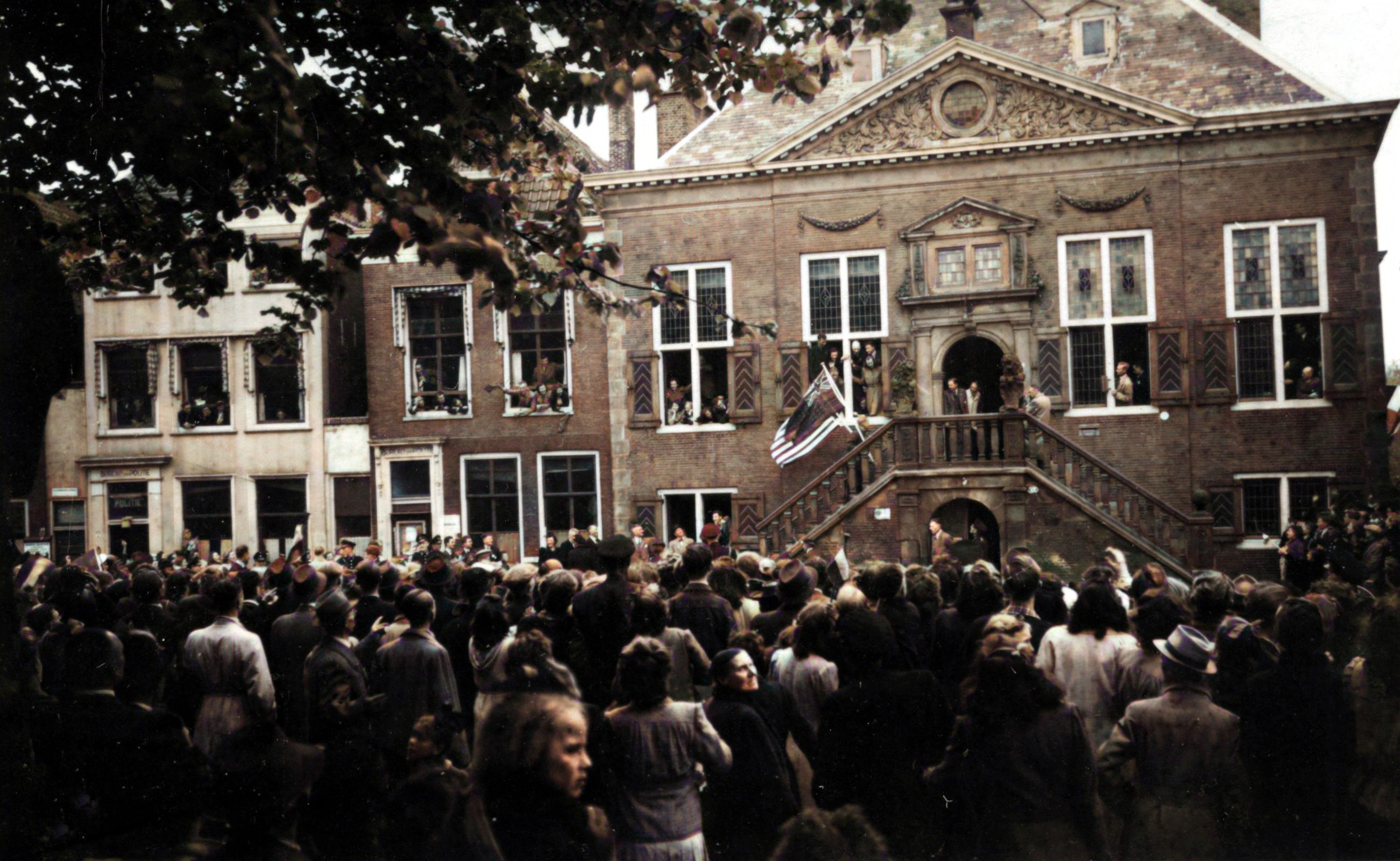 Malcolm Edwardsen, een van de drie ondergedoken Amerikaanse vliegeniers, loopt de trap op van het stadhuis met de Amerikaanse en Britse vlag. Even later hangen de twee vlaggen uit het torentje van het stadhuis. 